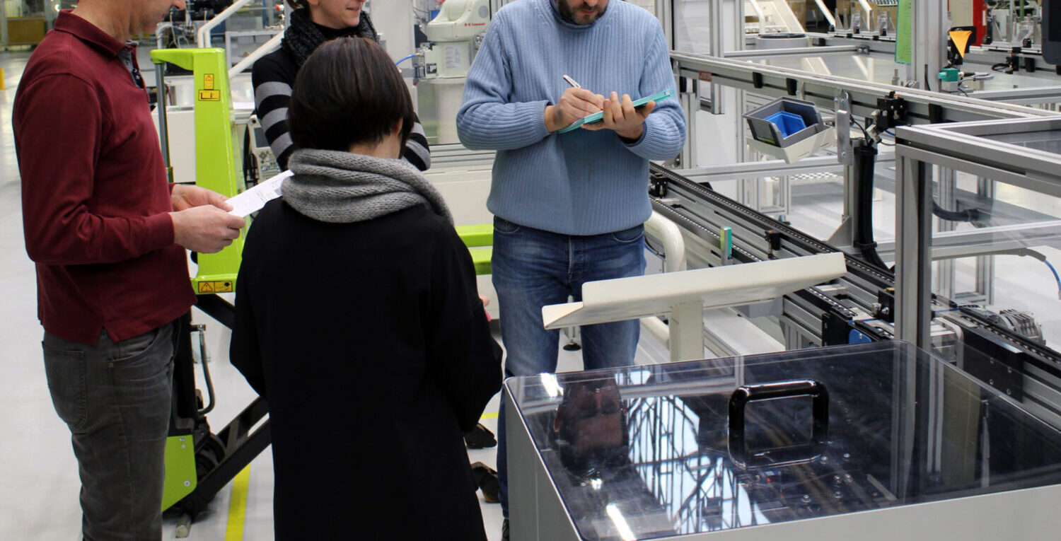 quattro studenti discutono in fabbrica durante il laboratorio taglab, formazione per la sicurezza dei dipendenti