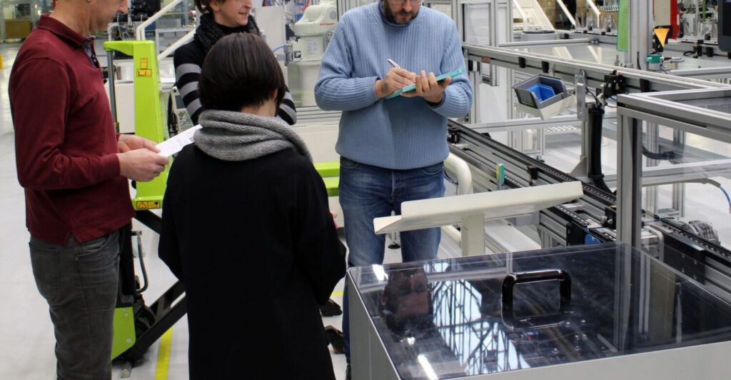 quattro studenti discutono in fabbrica durante il laboratorio taglab, formazione di sicurezza per i dipendenti