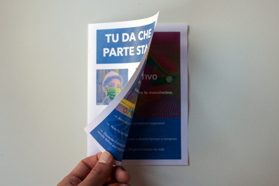 una mano apre il volantino di una comunicazione aziendale